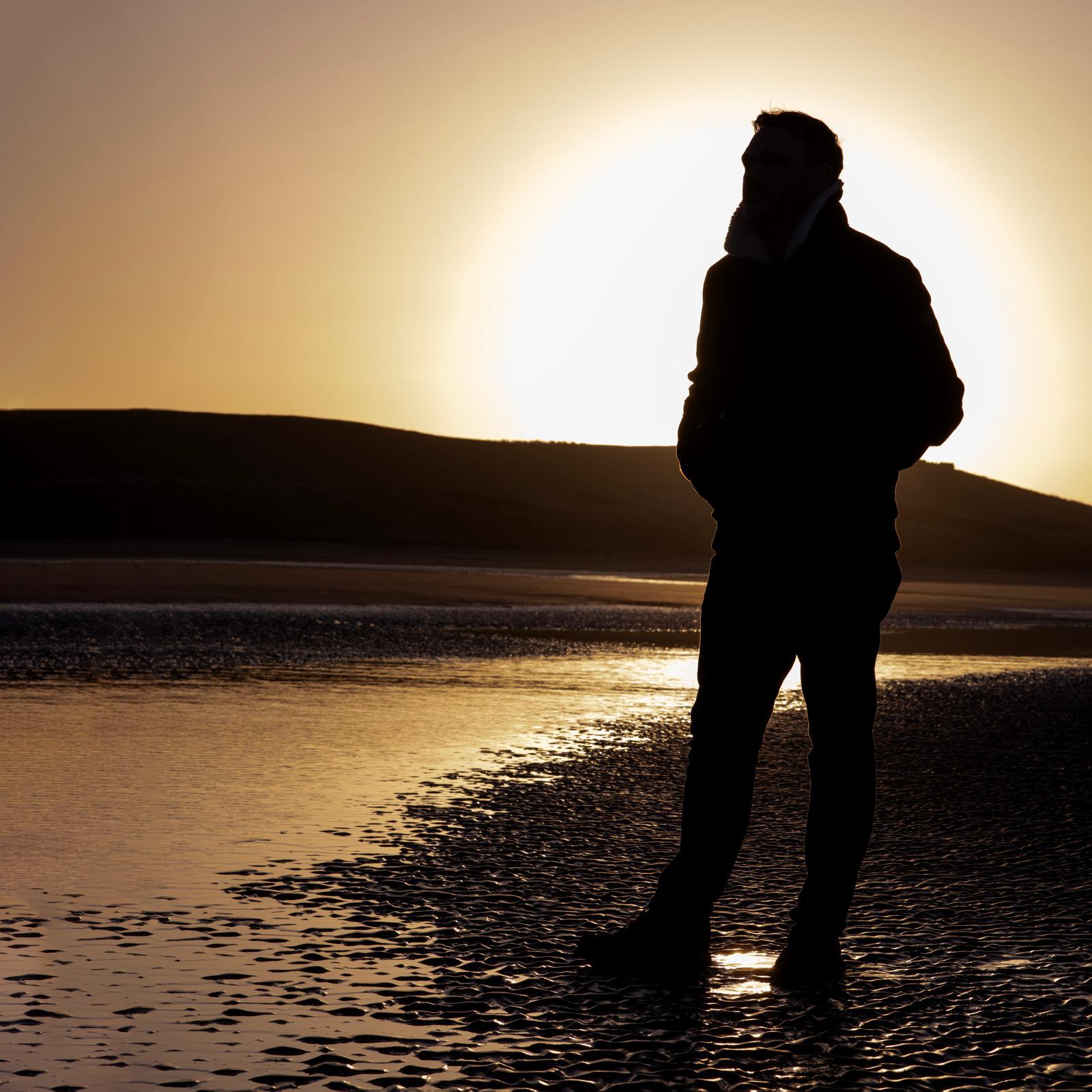 David standing on shoreline with reflection